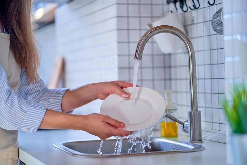 Flickan diskar innan hon ställer in disken i diskmaskin.
