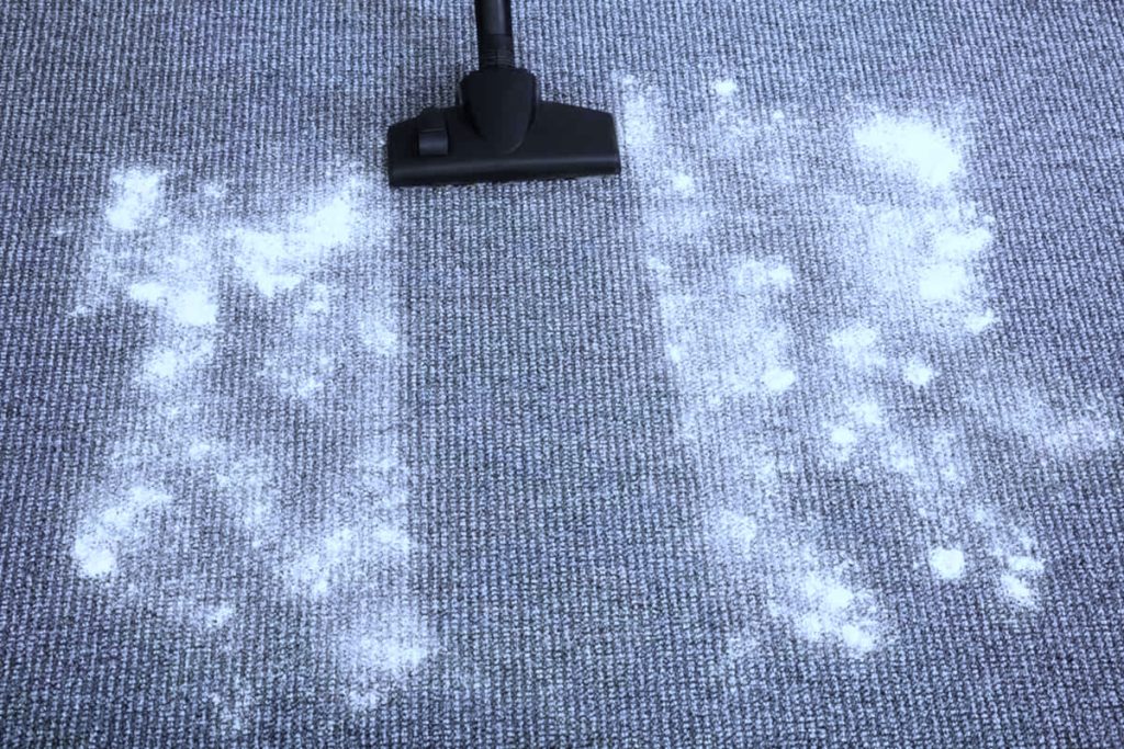 salt strödes på mattan och sugs upp med en dammsugare.